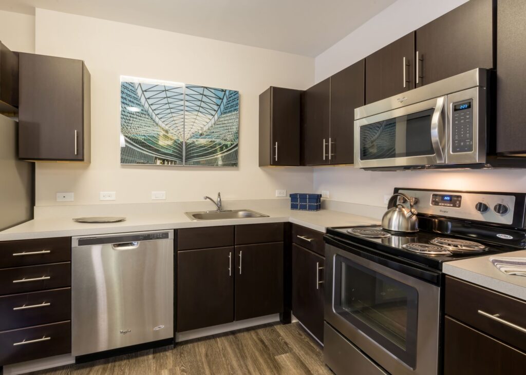 A kitchen with stainless steel appliances and dark wood cabinets.